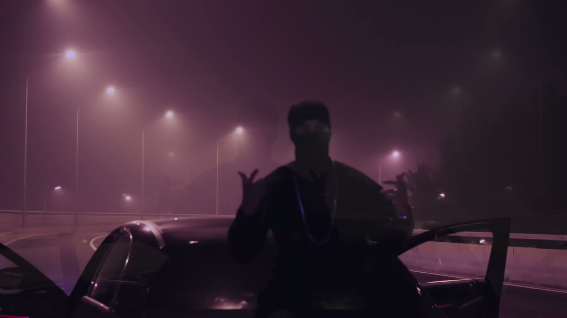 A masked figure standing between the open doors of a car on a fog-bound elevated roadway at night, streetlights receding into the haze under a magenta sky